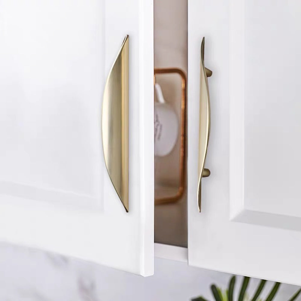 Custom brushed gold curved drawer pull for luxury furniture.