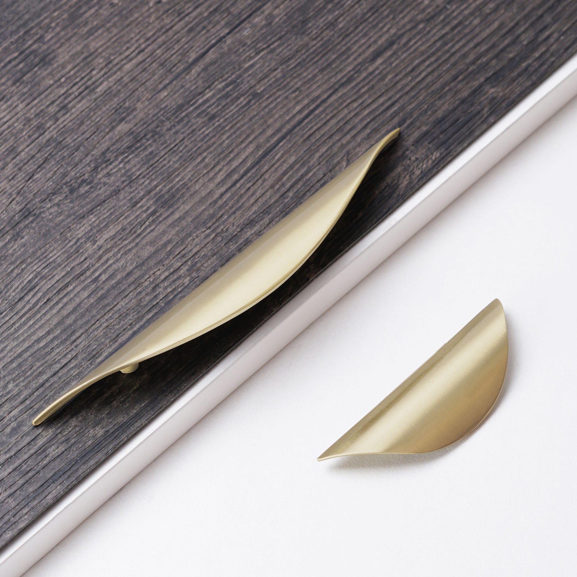 Luxury brushed gold curved pull handle for kitchen drawers.