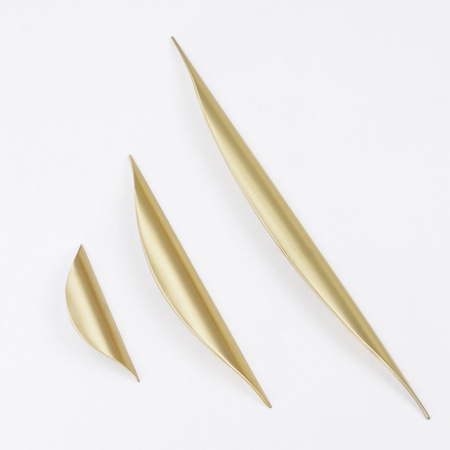 Contemporary brushed gold curved pull knob for furniture.