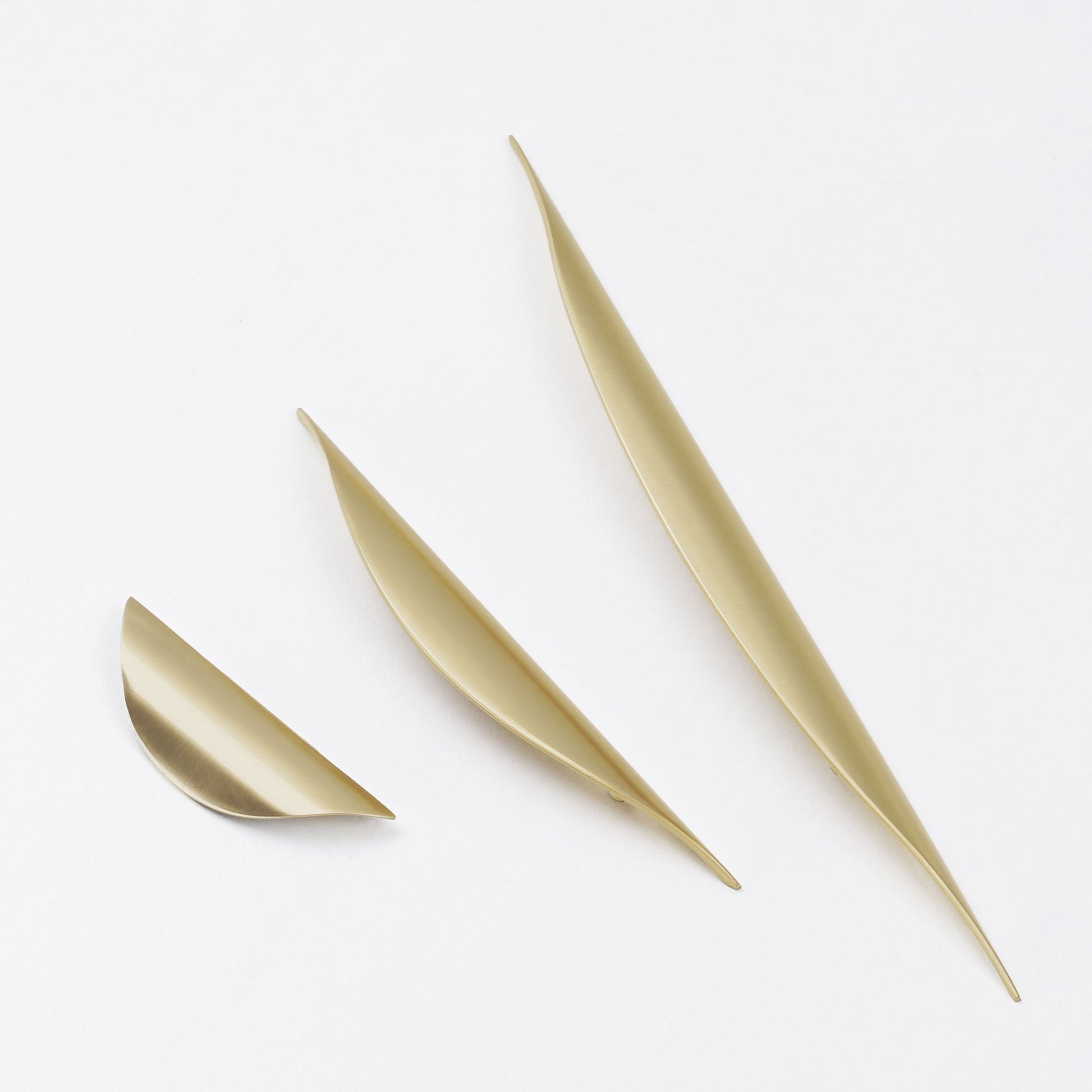 Minimalist brushed gold curved handle for wardrobe doors.